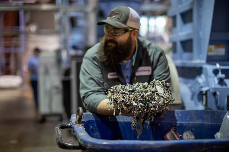 Employee holds shredded apparel © 2024 Debrand Employee holds shredded apparel © 2024 Debrand